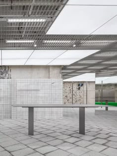 an empty bench sits in the middle of a room with tiled walls and flooring