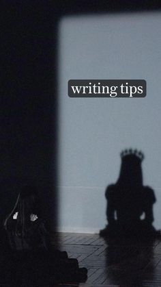 the shadow of a person sitting in front of a wall with writing tips on it