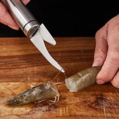 a person cutting up some food on top of a wooden table next to a knife