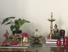 a glass table topped with books and vases filled with flowers on top of it