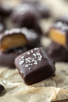 chocolate covered pieces of cake sitting on top of parchment paper