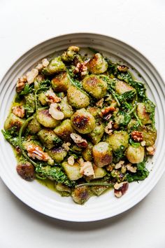 a white plate topped with brussel sprouts and nuts