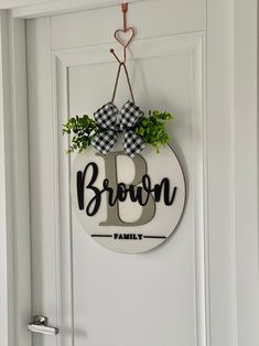 a door hanger with the word brown on it and a potted plant in front of it