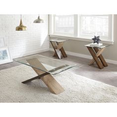 a glass table with wooden legs in a room next to a white rug and window