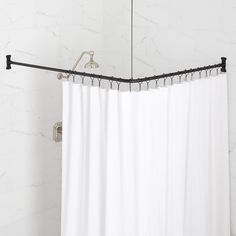 a white shower curtain hanging from a metal rod