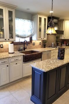 a large kitchen with white cabinets and granite counter tops, along with an island in the middle