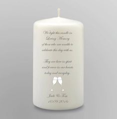 a white candle with two wine glasses on it and the words, we light this candle in loving memory