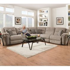 a woman sitting on top of a couch in a living room next to a coffee table