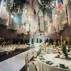 an elaborately decorated banquet hall with chandeliers and flowers on the ceiling is shown