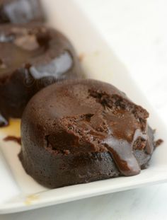 two chocolate desserts are on a white plate