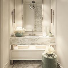 an elegant bathroom with marble counter tops and white flowers in vases on the vanity