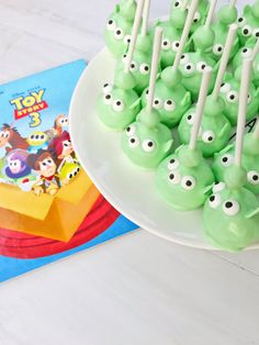 there are many green candies with googly eyes on them and a toy story book in the background