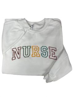 "Retro NURSE in rainbow lettering embroidered on a crewneck sweatshirt. Perfect for any nurse, LPN, RN and/or nurse's day, Nurse Graduates. The sweatshirt is a soft spun crewneck and is very soft cotton poly blend, which is so comfy. Embroidered text will be as shown as in the picture. It takes 1-2 weeks to make and process orders for shipping. If you require it sooner, you will need to purchase the \"rush order add-on\" Item Description: Unisex Men Sizing Cotton and Polyester Pull On Long Sleev Rainbow Lettering, Rainbow Letters, Embroidered Text, School Nurse, Nurses Day, Nursing Graduation, Embroidered Crewneck, Black Thread, Favorite Sweater