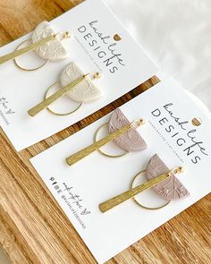 three pairs of hair clips sitting on top of a wooden table next to each other