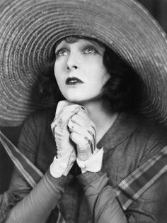 black and white photograph of a woman wearing a large hat