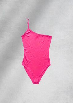 a pink one piece swimsuit on a grey background