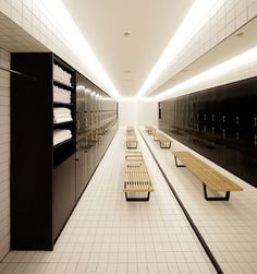 an empty locker room with benches and towel racks