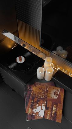 a record player sitting on top of a table next to candles