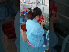 a woman in blue shirt working on red items