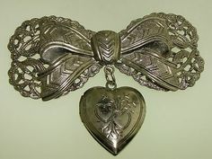 IT HAS BEEN WORN, IS IN NICE CONDITION AND GOOD WORKING ORDER! WITH HEART LOCKET! FAUX SILVER FILIGREE BOW PIN. Formal Bow Jewelry For Valentine's Day, Valentine's Day Formal Bow Jewelry, Vintage Metal Brooches For Gift, Vintage Jewelry For Valentine's Day Party, Victorian Metal Brooches As Gift, Elegant Silver Heart Brooch, Elegant Silver Heart Brooches, Elegant Silver Heart-shaped Brooches, Elegant Silver Heart-shaped Brooch