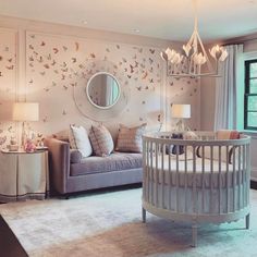 a baby's room with a crib, couch and mirror on the wall