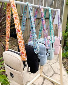 four purses are hanging on a rack outside