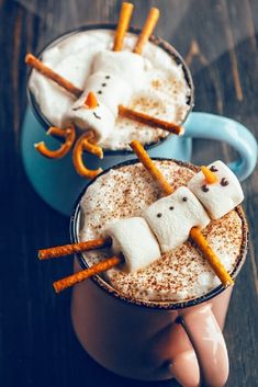 two cups filled with hot chocolate and marshmallows in the shape of ghosts