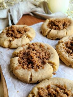 several cookies with crumbled toppings sitting on top of parchment paper