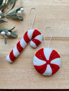 two red and white candy cane ornaments on a wooden table