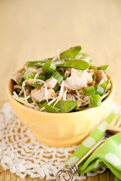 a yellow bowl filled with food on top of a wooden table