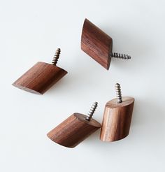 three wooden screws are placed next to each other on a white surface, with one being turned upside down