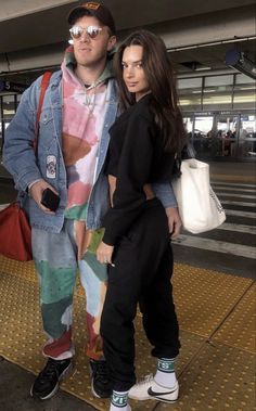 two people standing next to each other at an airport