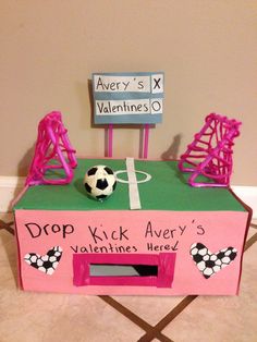 a pink and green box with a soccer ball on it that says drop kick avery's valentines here