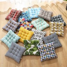 many different colored pillows on a wooden table