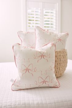 two pillows sitting on top of a white bed