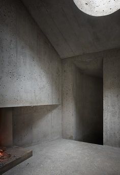 an empty concrete room with a fire place