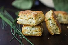 three biscuits stacked on top of each other next to some green leaves and a white bowl