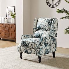 a blue and white chair sitting on top of a rug next to a wall clock