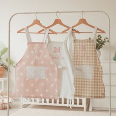 three aprons hanging on a rack in a room