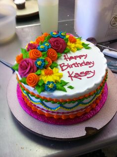 a birthday cake is decorated with flowers and the words happy birthday keey