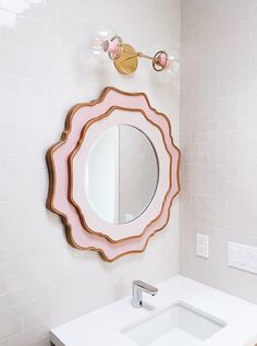 a bathroom sink with a mirror above it and a faucet on the wall