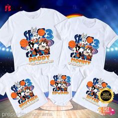 three t - shirts with cartoon characters on them in front of a basketball court and stadium lights