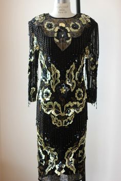 "Beautiful Beaded sequined Dress!! This is all silk...has a see through neck...with beads...and hanging beaded fringe throughout..just the right amount! Absolutely in Excellent condition with zip up back..oh wow this is a beauty!! Measuring: 45\" length Bust: 38\" Waist: 28\" Hip: 38\" Sleeves:22\" Beautiful!! Pet Free/smoke free Enjoy!" Gatsby Style Sequined Flapper Dress For Formal Occasions, Gatsby Style Sequined Flapper Dress For Formal Events, Sequin Gatsby Flapper Dress For Formal Events, Gatsby Style Sequin Flapper Dress For Formal, Formal Gatsby Flapper Dress With Sequins, Gatsby Style Floor-length Party Dress, Glamorous Fitted Sequin Dress With Beaded Fringe, Gatsby Style Beaded Fringe Cocktail Dress, Formal Sequined Flapper Dress For Party Season