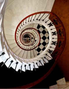 a spiral staircase with black and white tiles on it