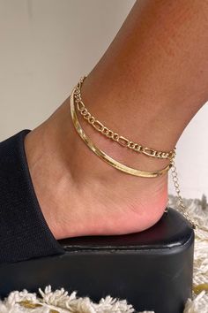 Side view of model wearing the Double The Trouble Anklet which features two gold layers, one layer with gold flat design and the other layer is a gold roping design. Trendy Gold Ankle Wrap Anklets, Adjustable Gold Metal Anklets, Gold Metal Anklets For Summer, Adjustable Gold Trendy Anklets, Adjustable Gold Ankle Wrap Anklet, Anklet Stack, Gold Anklet, Gold Flats, The Double