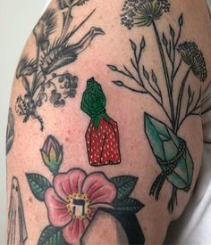 a woman's arm with tattoos and flowers on it