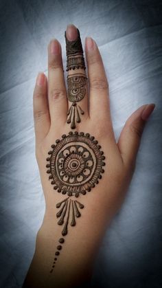 a woman's hand with henna tattoos on it