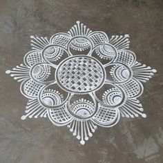 an intricately designed design on the ground in white ink, with circles and dots