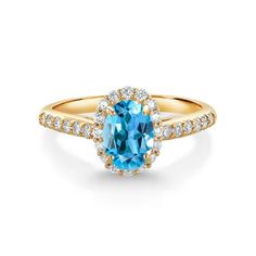 a gold ring with an oval blue topazte surrounded by small white and yellow diamonds