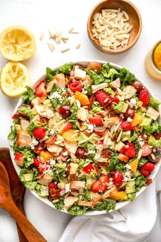 a salad is shown in a bowl with lemons and other ingredients